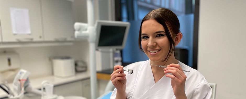 ZFA bei der Arbeit Eine ZFA mit einem medizinischen Instrument.