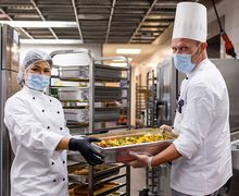 Für mehr Informationen hier klicken Eine Köchin und ein Koch präsentieren ein vegetarisches Gericht.