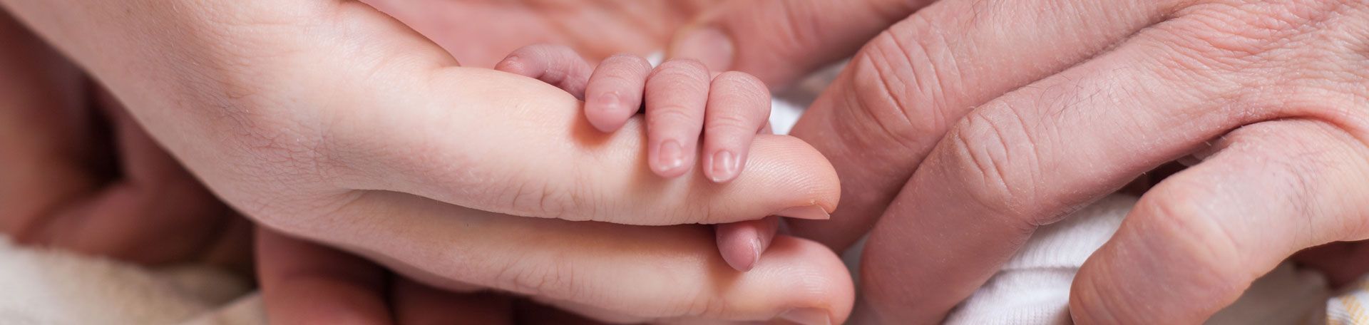 Elternschule Illustrationsbild: Babyhand in den Händen von Eltern