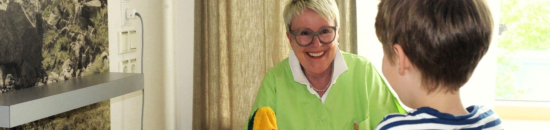 Eine Grüne Dame kümmert sich um einen kleinen Patienten © Petra Winkelhardt Eine grüne Dame mit Handpuppe im Gespräch mit einem Jungen