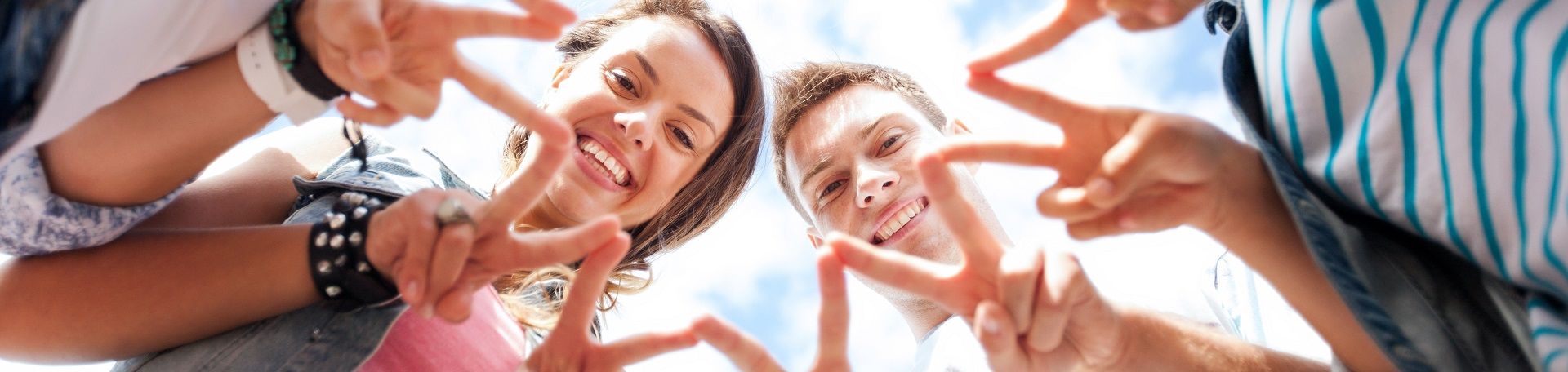 Eigenständigkeit und Lebensqualität - das ist das Ziel der Schmerztherapie für Jugendliche. © Syda Productions - stock.adobe.com Jugendliche, die mit Zeige- und Mittelfinger das Victory-Zeichen formen