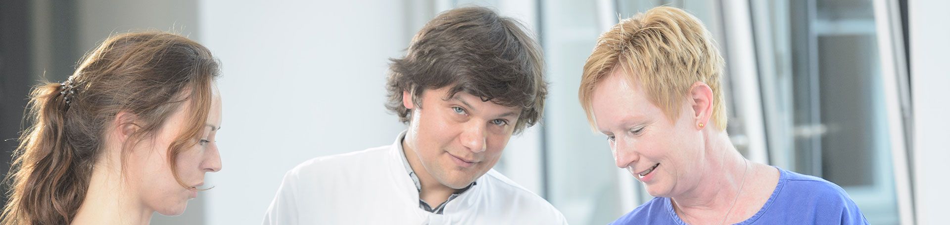 Arzt im Gepsräch mit Mitarbeiterinnen Arzt im Gespräch mit Mitarbeiterinnen