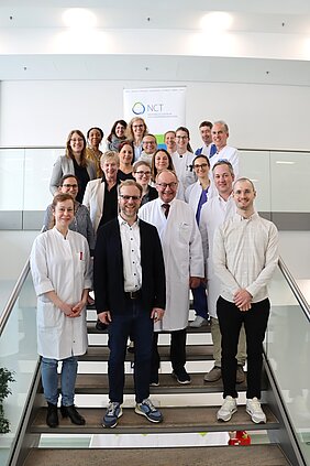 Gruppenbild des Würzburger Studienteams auf der Treppe des Zentrums für Innere Medizin - Hochformat 