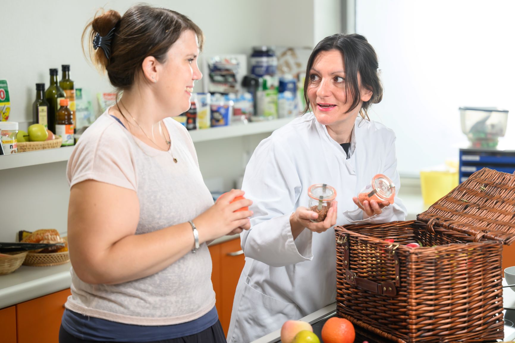 Würzburger Adipositas Studie - Ernährungsberatung in Diätküche Studienteilnehmerin und Studienärztin beugen sich über Obstkorb in der Diätküche