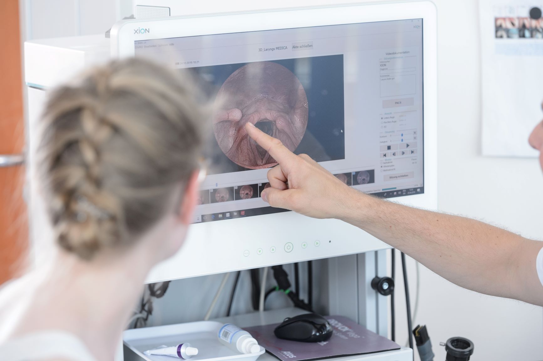 Endoskopie des Kehlkopfes Arzt erläutert am Monitor Aufbau und Funktionen des Kehlkopfes