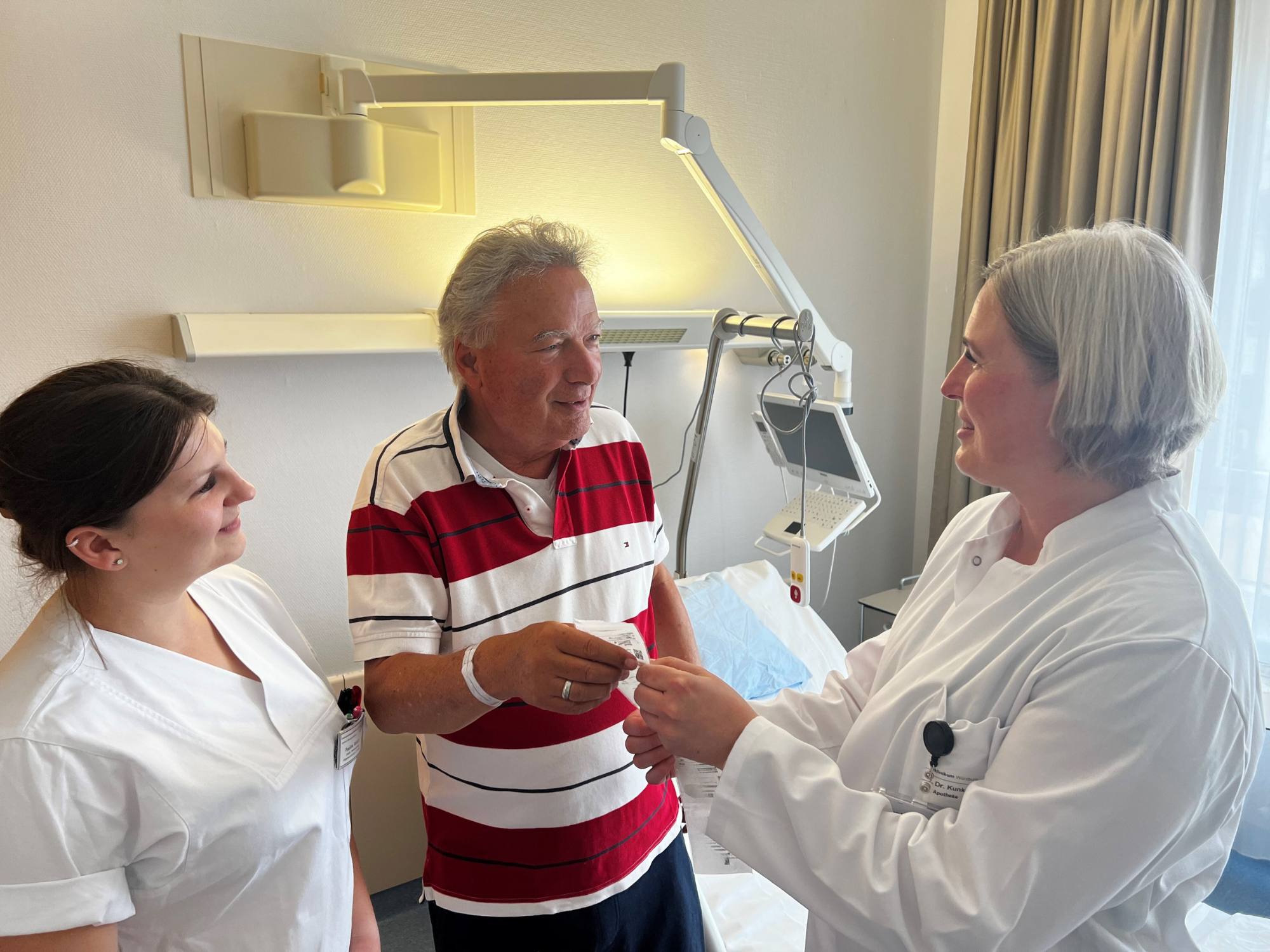 UKW-Chefapothekerin Dr. Mareike Kunkel (r.) und Paulina Kolacz, stellvertretende Stationsleitung (l.), erläutern das neue Ausgabesystem für die Medikamente im Patientengespräch.