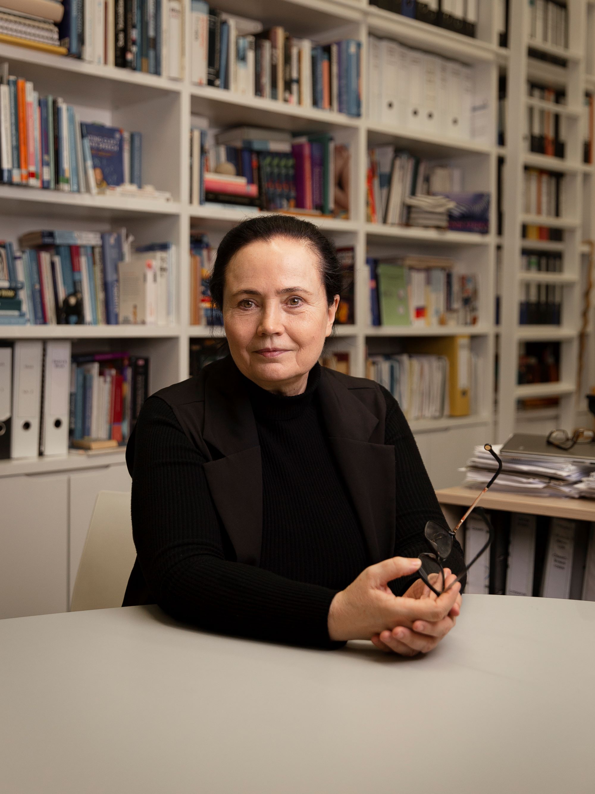 Kathleen Wermke Kathleen Wermke sitzt am Besprechungstisch vor dem Bücherregal in ihrem Büro im Zentrum für vorsprachliche Entwicklung und Entwicklungsstörungen