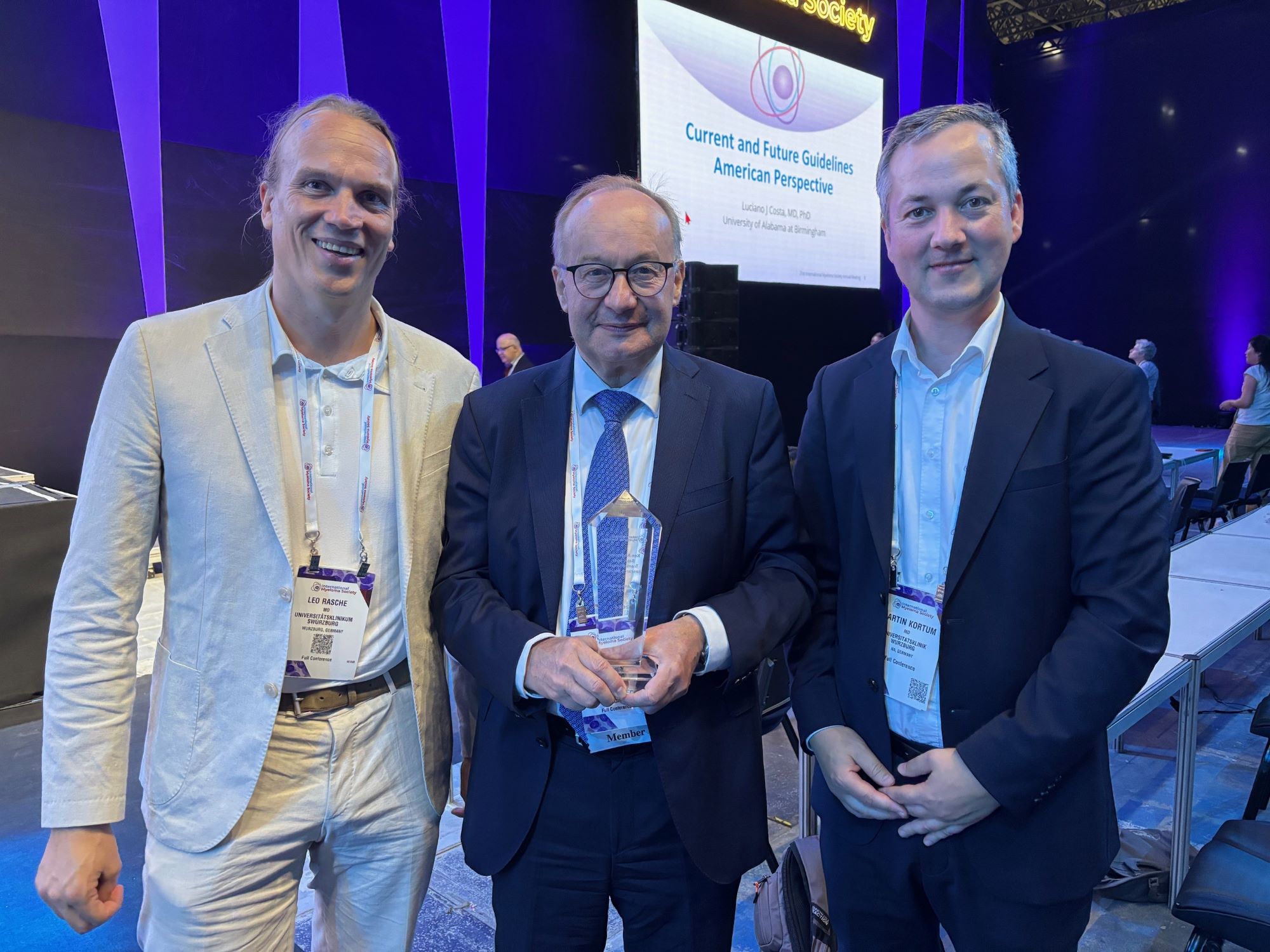 Rasche_Einsele_Kortuem Leo Rasche (links) und Martin Kortüm (rechts) gratulieren beim Kongress Hermann Einsele zum Preis, den er in seinen Händen hält.