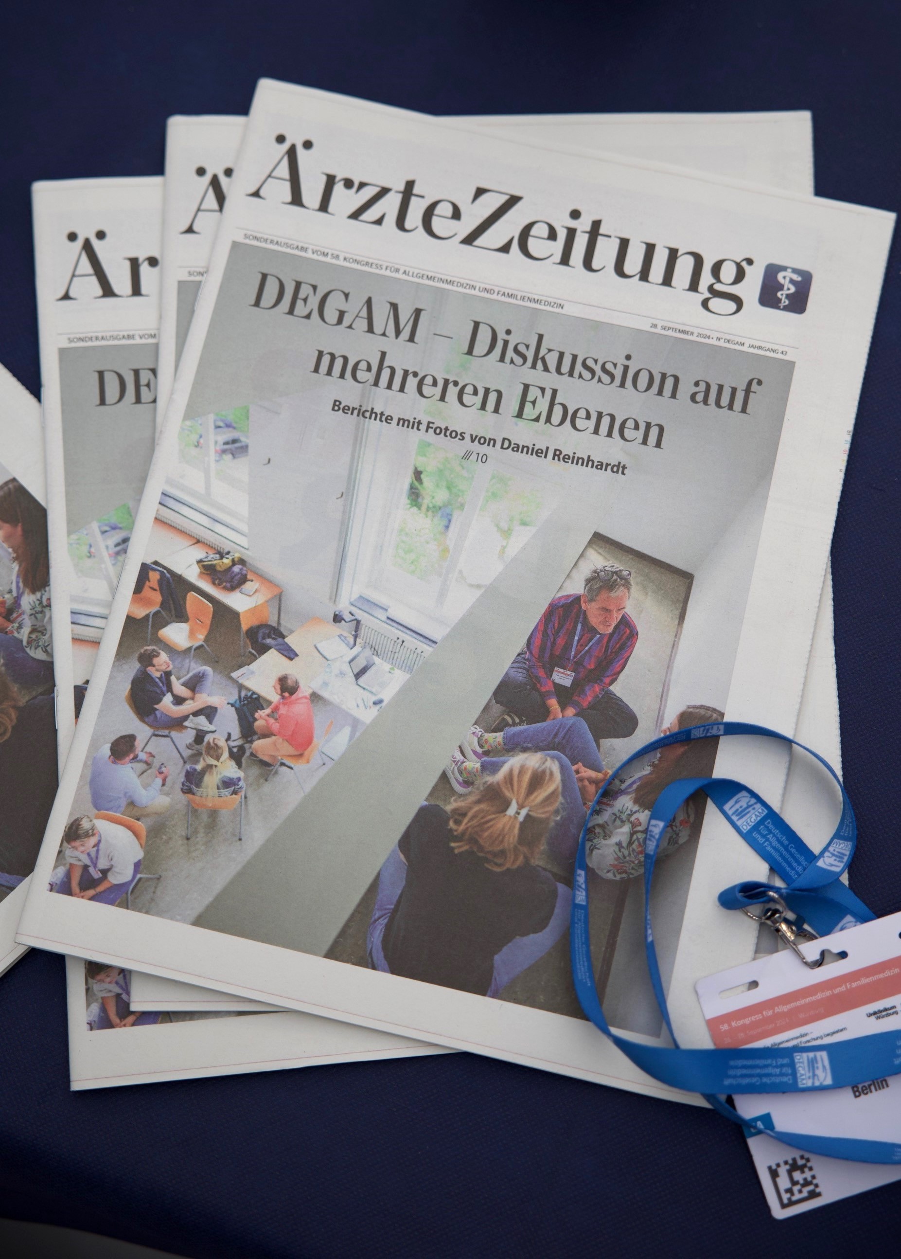 DEGAM - Kongressausgabe Mehrere Kongressausgaben liegen übereinander, rechts im Bild ein Kongressausweis
