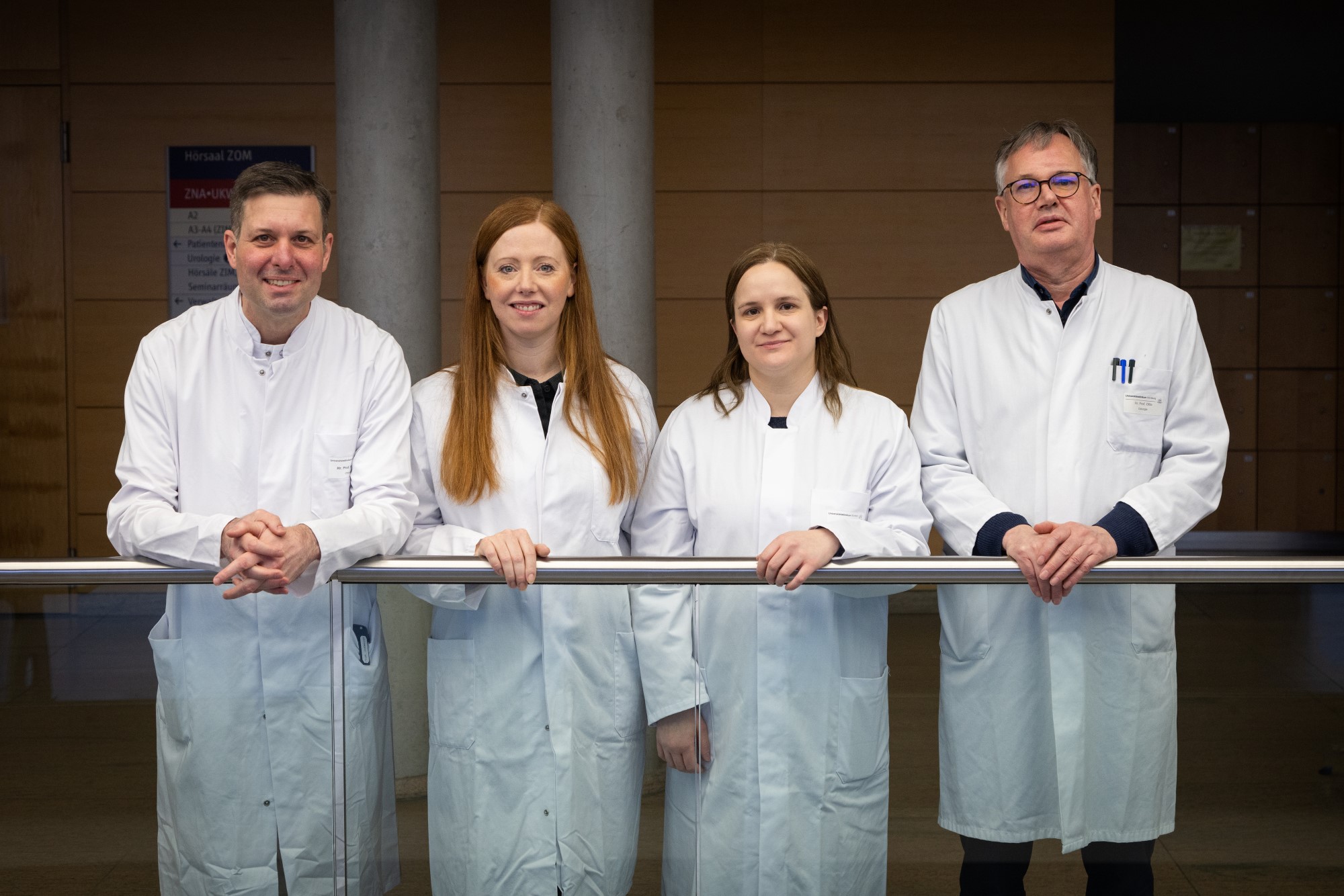 Nicolas Schlegel und Team Nicolas Schlegel, Anne Rech, Mahasen Saati und Christoph Otto stehen in weißen Kittel in einer Reihe an einem Geländer