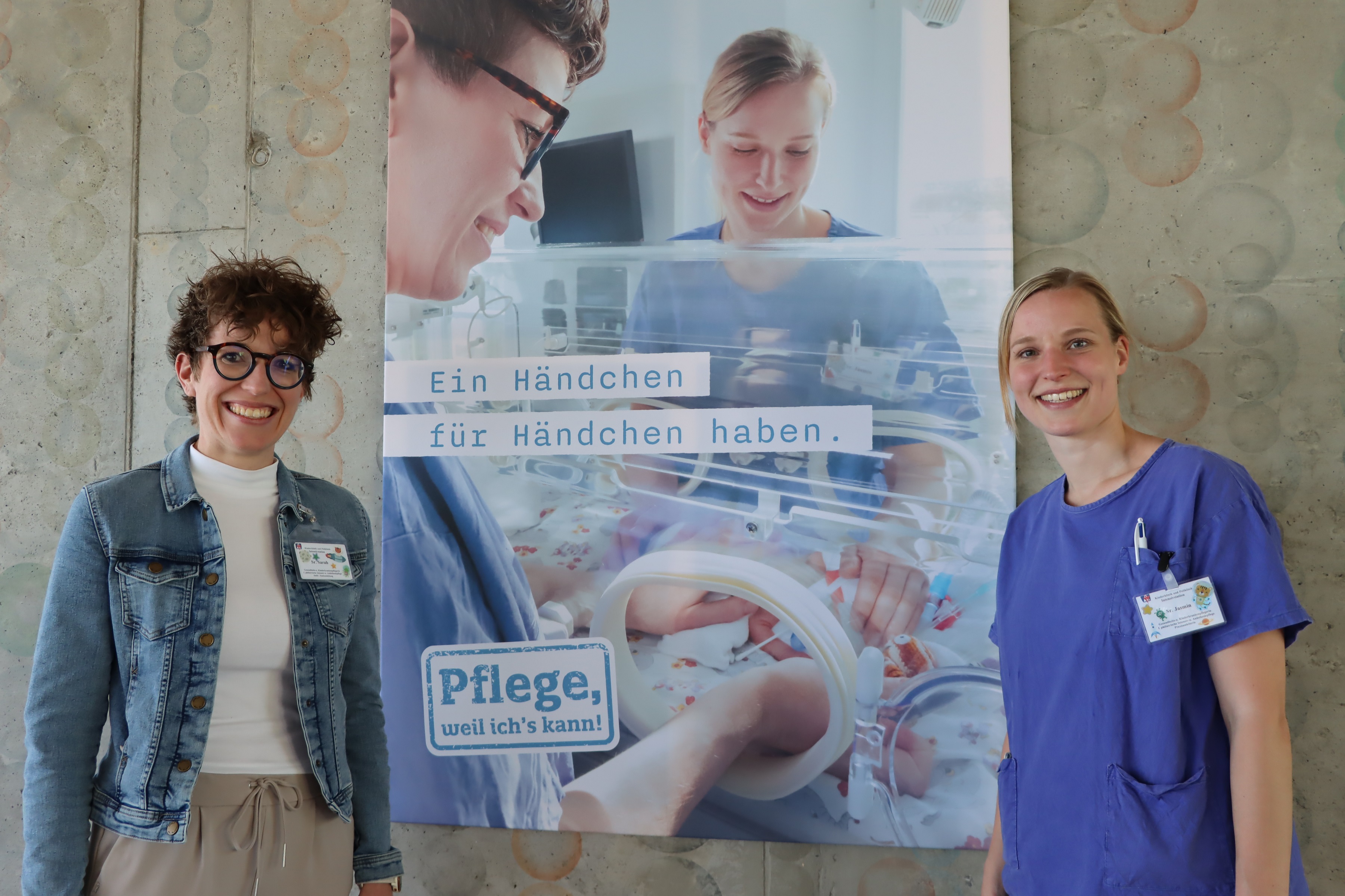 Sarah Schuster (l.) und Jasmin Sauer arbeiten zusammen in der Kinderintensivpflege am UKW. Die Ausstellung zeigt sie bei der gemeinsamen Arbeit mit den kleinsten Patienten. Foto: UKW / Stefan Dreising